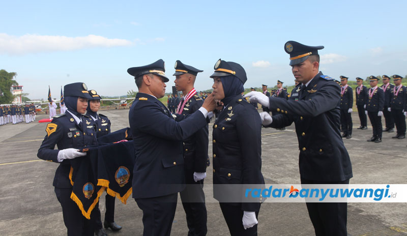 TERBAIK: Sekretaris BPSDM Perhubungan menyematkan tanda kelulusan kepada perwakilan wisuda Perwira Transportasi Udara di Kampus API Banyuwangi Jumat (4/8) lalu.