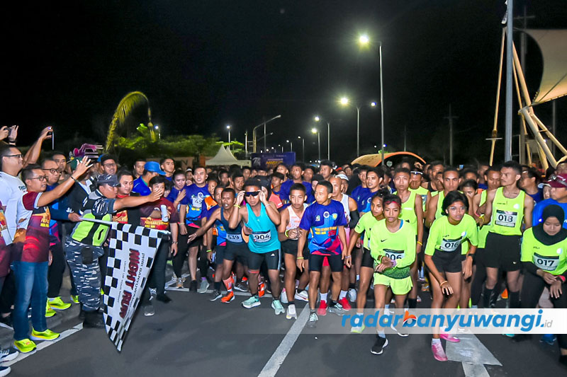 KIBARKAN BENDERA START: Sekkab Mujiono memberangkatkan peserta lari Banyuwangi Night Run dengan start dan finish di Pantai marina Boom, Sabtu malam (5/8).