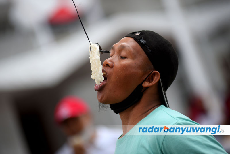 SKILL MAKAN: Warga beradu cepat makan kerupuk yang digantung.