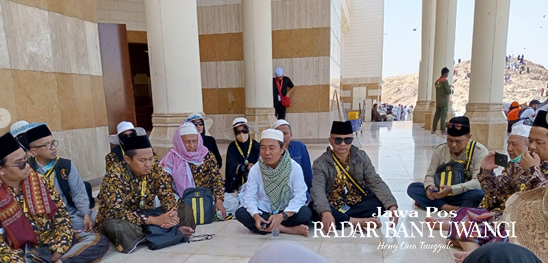 TEMPAT BERSEJARAH: H. Samsudin Adlawi (tengah peci putih) menjelaskan sejarah sekaligus mengajak jamaah melantunkan Selawat Badar di Jabal Uhud.