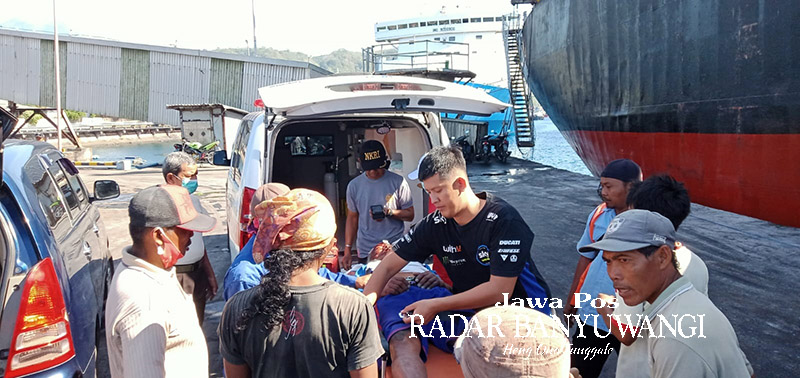 DINAIKKAN AMBULANS: Warga mengevakuasi Maadin setelah mengalami kecelakaan kerja di dermaga Pupuk Pusri, Desa Ketapang, Banyuwangi, Jumat (11/8).