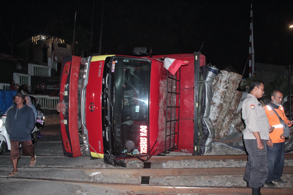 MENGANGGU: Truk Nissan Euro 2 yang terguling di lintasan KA membuat KA Pandanwangi dan KA Sritanjung tidak bisa melintas pada Rabu (9/8) malam.