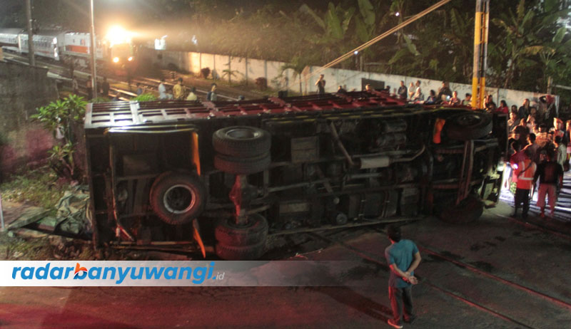 MELINTANG DI JALAN: Truk Nissan Euro 2 bermuatan kayu mahoni terguling di lintasan KA barat Stasiun Temuguruh, Desa Temuguruh, Kecamatan Sempu, Rabu (9/8) pukul 17.00.