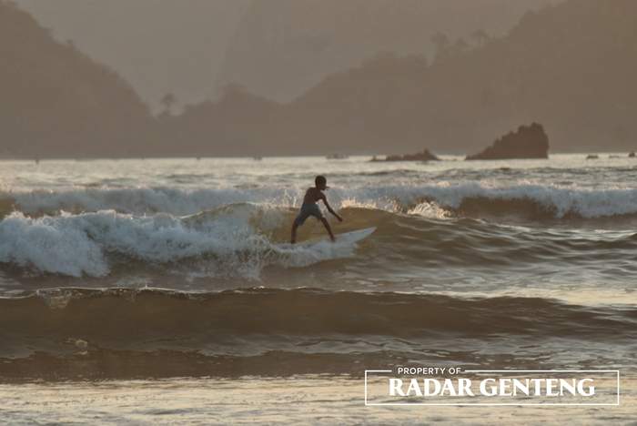 BERANI: Salah satu surfer muda bermain surfing di Pantai Pulau Merah, Dusun Pancer, Desa Sumberagung, Kecamatan Pesanggaran, Minggu (13/8)