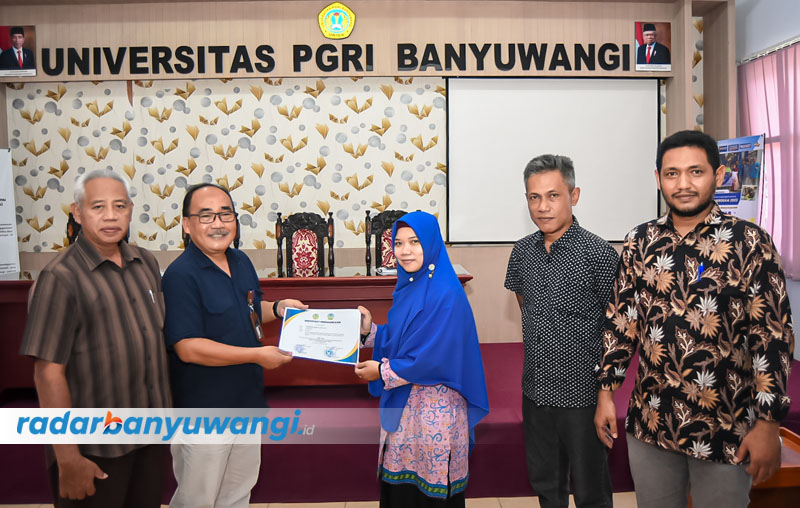 BERI SEMANGAT: Rektor Uniba Dr H Sadi MM (berkacamata) memberikan sertifikat kepada salah satu dosen yang berhasil lolos program dana hibah Dikti 2023.