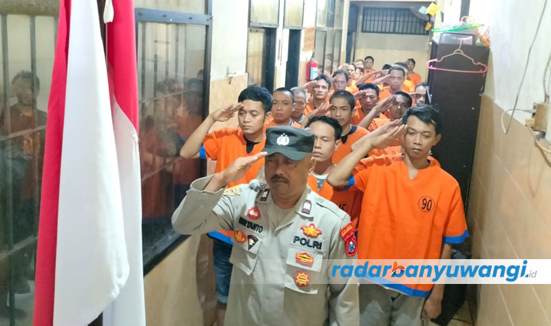 HORMAT BENDERA: Ratusan tahanan Polresta Banyuwangi memperingati HUT Kemerdekaan RI ke-77 di dalam Ruang Tahanan Polresta Banyuwangi, Kamis (17/8).