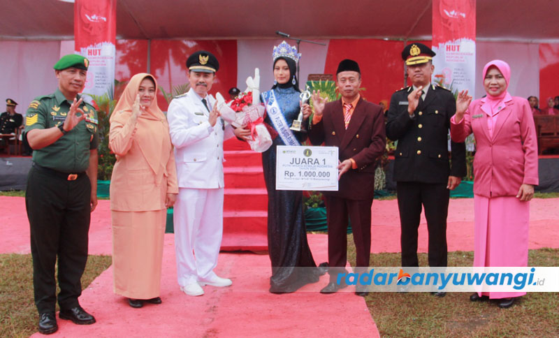 Camat Rogojampi Danisworo (kiri) didampingi Kepala MTsN 10 Banyuwangi Sugeng Mariyono memberikan hadiah kepada Alicia Alexandra di Lapangan Lugjag, Rogojampi, Kamis (17/8).