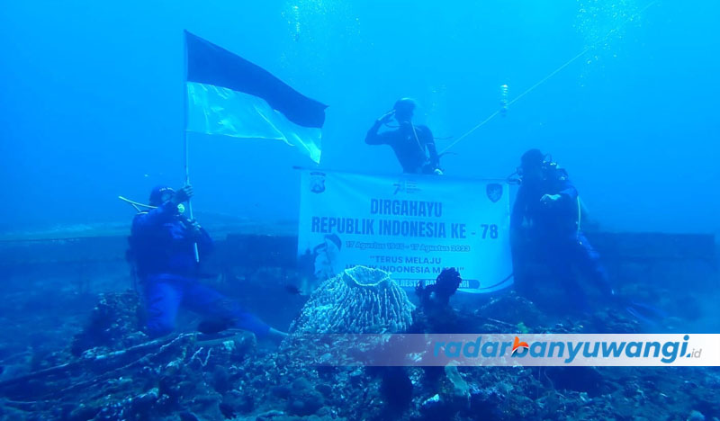 BERKIBAR: Kasatpolairud Kompol Mahsyur Ade bersama anggotanya mengibarkan bendera merah putih di dasar laut perairan selat bali, Jumat (18/7).