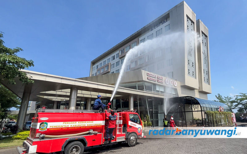 Petugas pemadam kebakaran menyemprotkan air kea rah bangunan Hotel Aston dalam simulasi, Selasa (22/8).