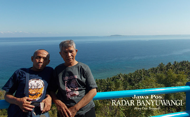 EKSOTIS: Dua pelanggan koran Jawa Pos Radar Banyuwangi Rahmat Sudiono (kiri) dan KH Astro Junaidi foto dengan latar belakang laut biru dari atas Bukit Malimbu, Lombok Barat.