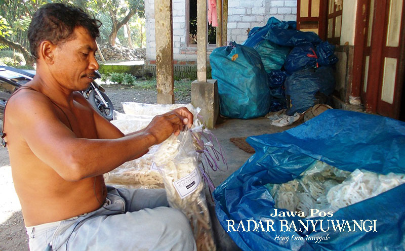 Perajin memasukkan kerupuk ke dalam plastik sebelum dijual ke pelanggan.