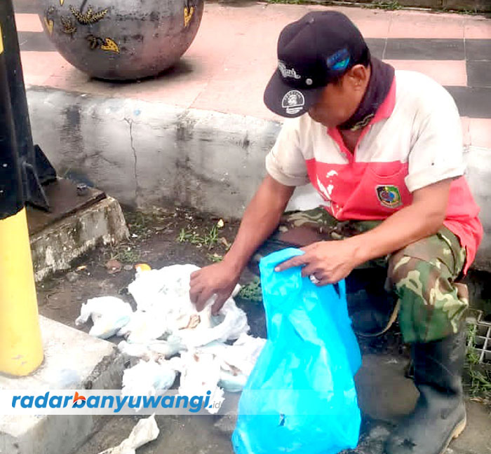 WAJAH KOTA: Petugas kebersihan memungut sampah popok sekali pakai di kawasan simpang empat Karangente, Banyuwangi, Jumat pagi (25/8).