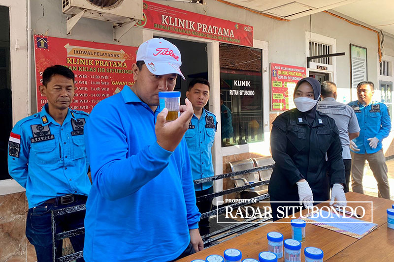 DETEKSI DINI: Kepala Rutan Kelas IIB Sitibondo Rudi Kristiawan ( kiri) melihat hasil tes urine milik anggotanya, Minggu (27/8).