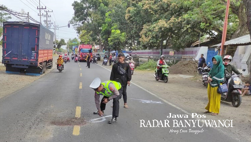 DITANDAI DENGAN PILOK: Anggota Satlantas Polresta Banyuwangi melakukan olah TKP kecelakaan dekat PT TIM, Kelurahan Klatak, Kecamatan Kalipuro, Minggu (27/8).
