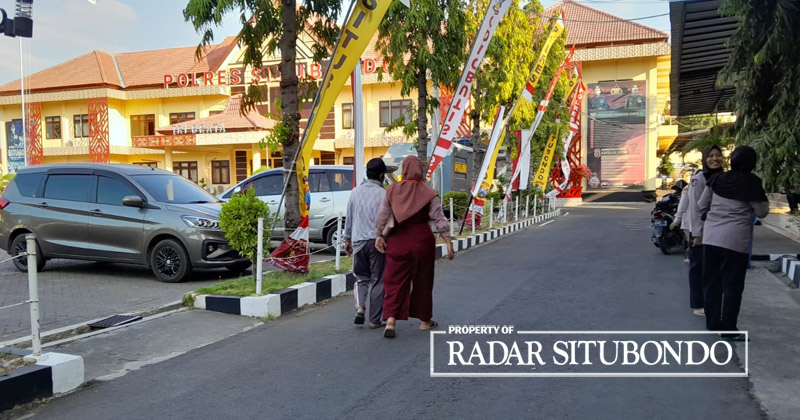 JENGUK TERDUGA: Seoarang bapak didampingi putrinya menjenguk Ibu Sukarlin, warga Desa Paowan, Kecamatan Panarukan di halaman depan Mapolres Situbondo, Kamis (31/8).