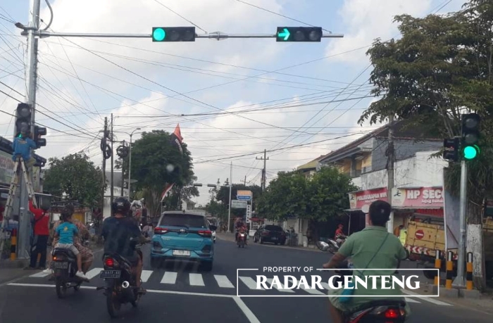 TERPASANG: Teknisi mencoba lampu traffic light di jalan simpang lima Desa Jajag, Kecamatan Gambiran, Selasa (5/9) pagi.
