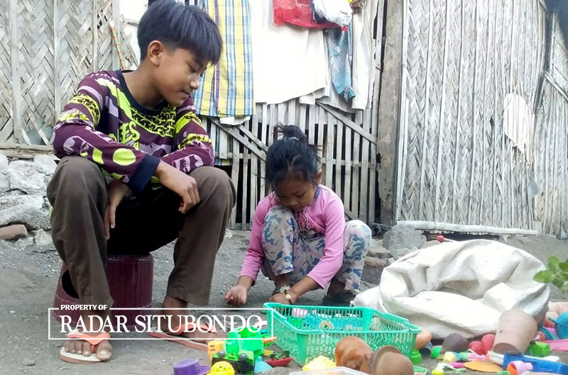 ISI WAKTU KOSONG: Doni Kurniawan menemani adiknya yang asyik bermain di halaman rumahnya di Desa Sumberanyar, Kecamatan Banyuputih, Situbondo, Selasa (5/9) lalu.