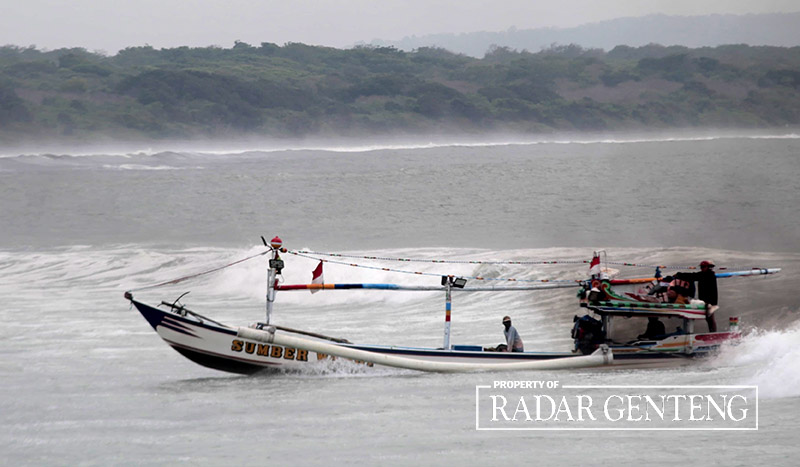 DIKEJAR OMBAK BESAR: Nelayan dengan perahunya hendak memasuki perairan Plawangan menuju Pelabuhan Grajagan, Desa Grajagan, Kecamatan Purwoharjo, Rabu (6/9).