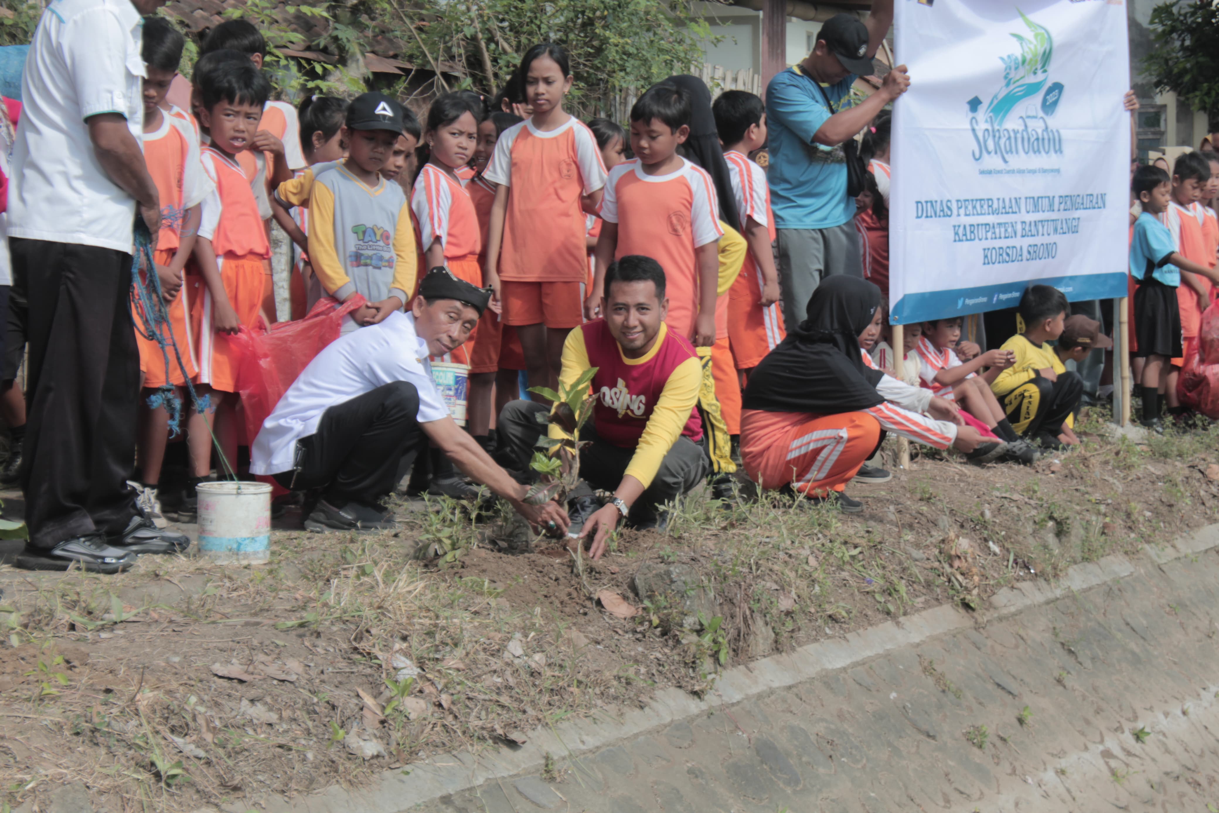 PEDULI SUNGAI: Korsda Srono Eko Susanto bersama Kasek SDN 1 Blambangan Ali Sodiqin menanam pohon di pinggir sungai di dekat sekolahnya, Jumat (8/9).