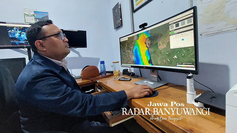 PRAKIRAWAN: I Gede Agus Purbawa menunjukkan prakiraan cuaca di Banyuwangi melalui layar monitor di kantor BMKG Banyuwangi, Minggu (10/9).