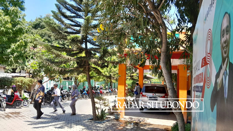 JAM ISTIRAHAT: Dua guru dan satu siswa melintas di halaman SMKN 2 Situbondo Senin lalu (11/9).