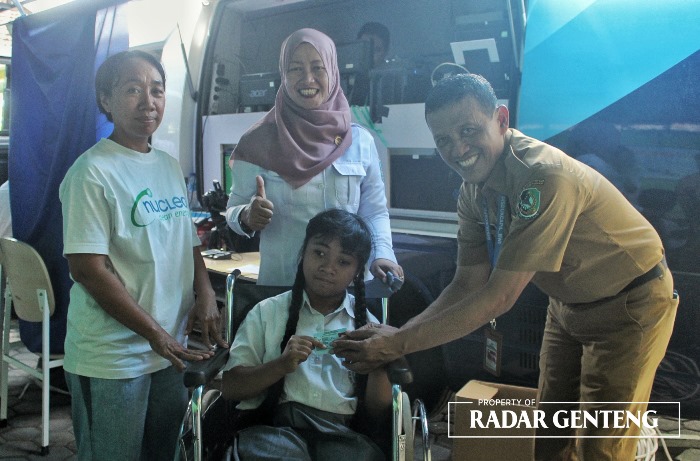 17 TAHUN: Salah satu siswa berkebutuhan khusus menunjukkan E-KTP miliknya bersama Kepala Dispendukcapil Banyuwangi, Juang Pribadi (baju cokelat) dan Kepala SLB PGRI 3 Cluring Nyoman Henny Parwati, Rab