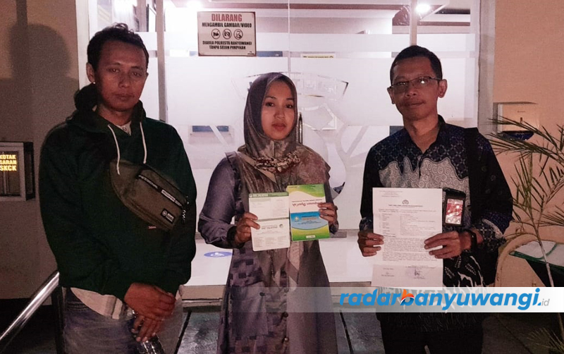 TEMPUH JALUR HUKUM: Maryani Kavita Dewi (tengah) didampingi kuasa hukumnya, Ahmad Rifai (kanan), menunjukkan bukti laporan ke Polresta Banyuwangi, Rabu malam (13/9).