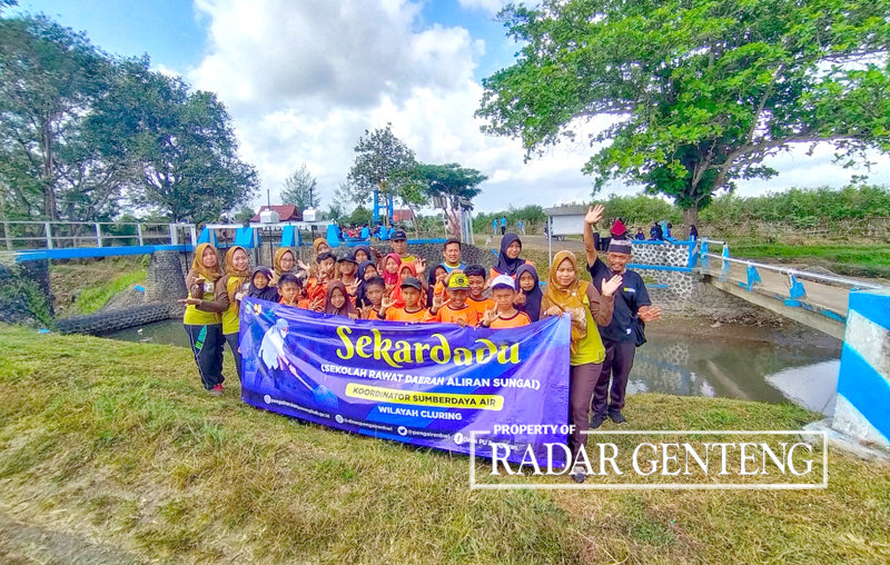 JAGA KELESTARIAN: Korsda Cluring Sugiyono (kanan) bersama para guru dan siswa SDN 4 Benculuk usai penanaman bibit pohon sukun di dekat Dam Pancursari, Desa Benculuk, Kecamatan Cluring, Jumat (15/9).