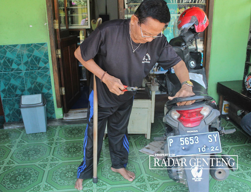 MENGGUNAKAN TONGKAT: Mat Sirat saat membuat kunci duplikat pada salah satu pelanggan di rumahnya Dusun Krajan, Desa Kalibaruwetan, Kecamatan Kalibaru, Jumat (15/9).