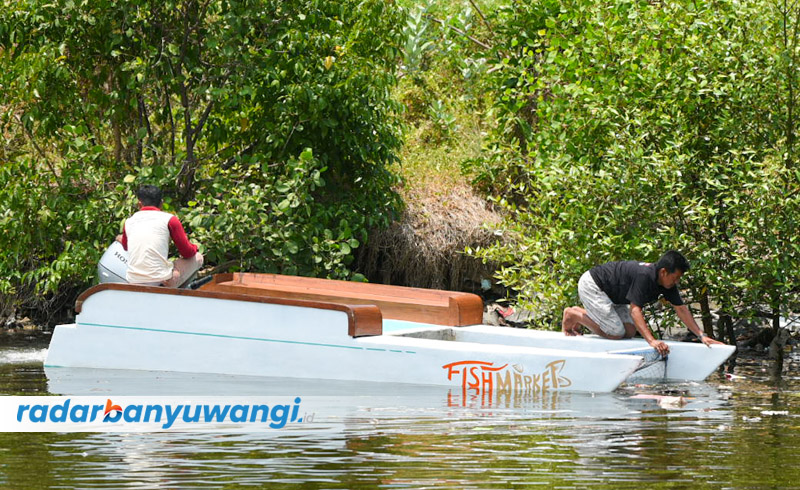 LEBIH PRAKTIS: Anggota Pokdarwis Kampung Mandar Amad bersama Ketua KUB Nelayan Kampung Mandar Hariyono membersihkan sampah di muara plengsengan, kawasan Pantai Boom, Senin (18/9).