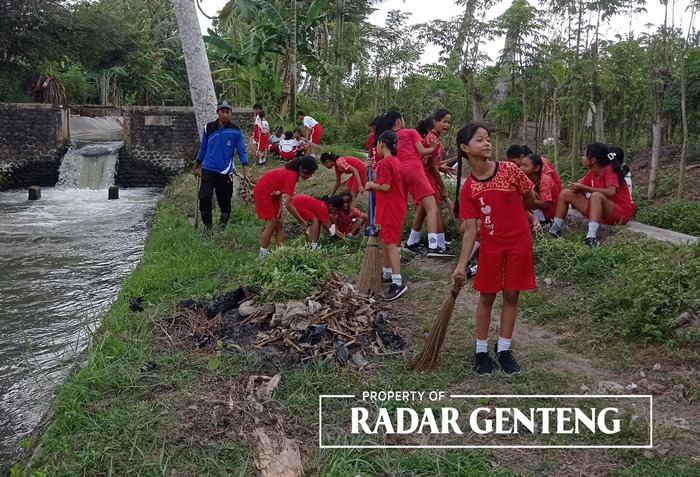 KOMPAK: Siswa, dewan guru SDN 1 Sambimulyo, dan petugas dari Korsda Bangorejo bersih-bersih sungai di sekitar Dam Sambirejo, Selasa (19/9).