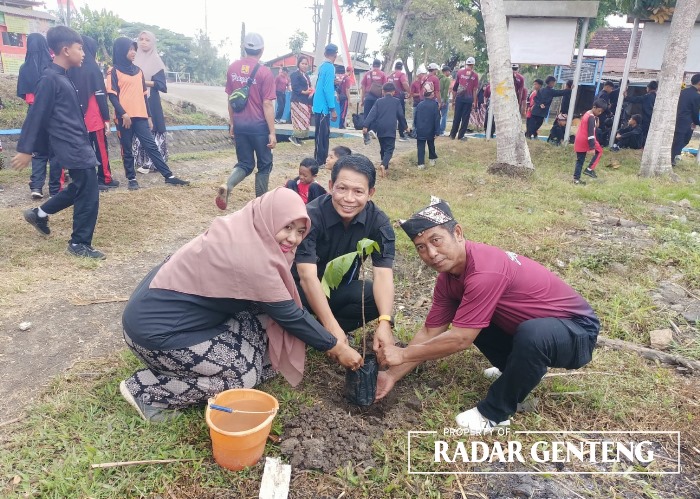 IKUT ANDIL: Agus Mulyono bersama Kepala SDN 3 Sarimulyo Tri Dia Astutik, dan Korsda Pesanggaran Sugiyono menanam pohon petai, Kamis (21/9)