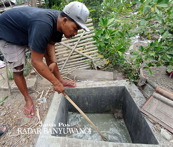 LIMBAH: Ahmad Aldi Gusnantoro memeriksa penampung limbah tahu yang digunakan sebagai biogas, Jumat (22/9).