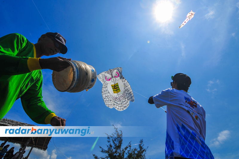 SIANG PANAS: Warga menerbangkan layangan hias dengan motif burung hantu.