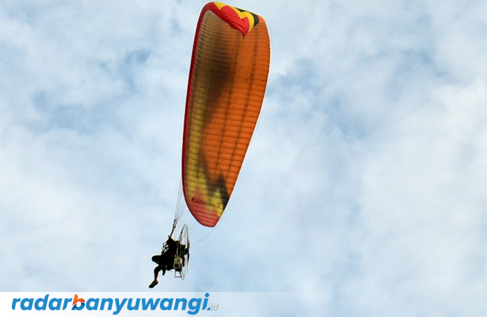 MANUVER: Pilot melakukan atraksi dengan menggunakan paramotor di atas kawasan Pantai Plengklung (G-Land), Kecamatan Tegaldlimo, Banyuwangi.
