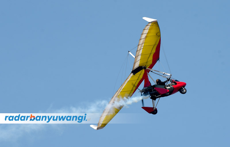 BERMESIN: Pilot mengendalikan pesawat microlight di atas kawasan Pantai Boom Banyuwangi.