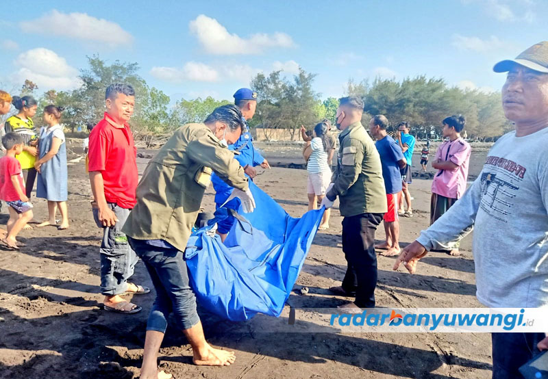 Anggota Satpolairud Polresta Banyuwangi mengevakuasi mayat yang ditemukan tergeletak di pinggir Pantai Sobo, Kecamatan Banyuwangi, Minggu (24/9).