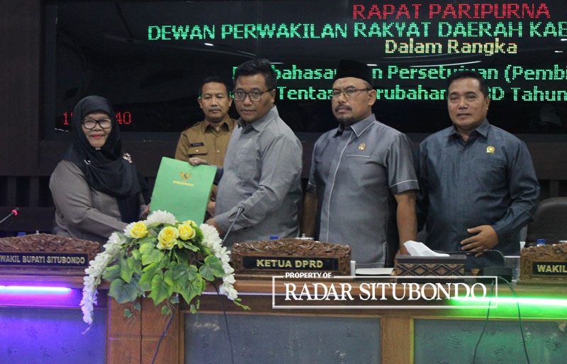 RAPAT BERSAMA: Wakil Bupati Situbondo, Nyai.Hj. Khairani menyerahkan draf PAPBD kepada Ketua DPRD Situbondo, Edy Wahyudi didampingi wakil ketua DPRD dan Sekwan, di ruang paripurna DPRD, Senin (25/9).