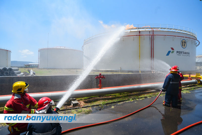 SEMPROTKAN AIR: Tim brigade penanggulangan api memadamkan kebakaran tangki vertikal 17 di depo BBM Pertamina Tanjung Wangi, Selasa (26/9).