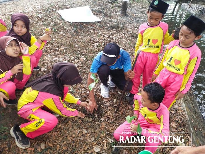 LESTARIKAN SUNGAI: Siswa kelas VI MI Al Amien bersama petugas pengairan dari Korsda Tegaldlimo menanam bibit kopi di tepi saluran sekunder Kalipait, Desa Kendalrejo, Kecamatan Tegaldlimo, Selasa (26/9