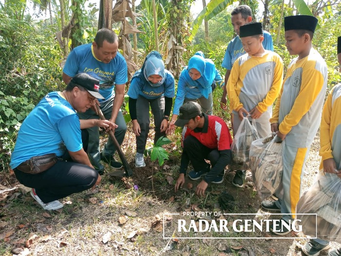 SEKARDADU: Tim Korsda Genteng bersama siswa MI Tarbiyatul Athfal 1 menanam pohon di Dusun Semalang, Desa Sumbersari, Kecamatan Srono usai membersihkan sungai, Kamis (27/9).