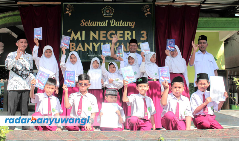 IKUT LOMBA: Kepala MIN 3 Banyuwangi Asro&rsquo;i (kiri) bersama 13 siswa mendaftar Liga Puisi 2023 di sekolahnya, Senin (25/9).