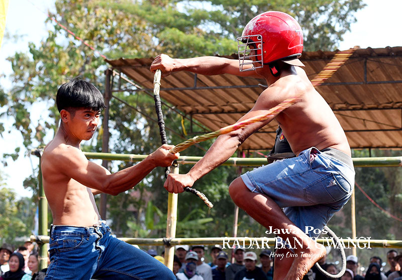 Dua pemain saling pukul di acara tiban di Desa Tamanagung, Kecamatan Cluring, Banyuwangi. Tradisi kuno ini digelar untuk meminta hujan.