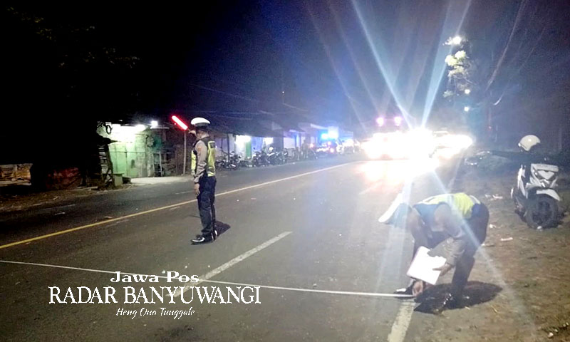 MENINGGAL DUNIA: Anggota Satlantas Polsek Rogojampi melakukan olah kejadian tempat perkara kecelakaan di jalan raya Kabat, Minggu dini hari (1/1).