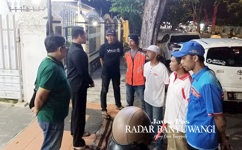 TINDAKAN PERSUASIF: Petugas Dishub Banyuwangi memberikan teguran kepada jukir liar yang mangkal di Jalan Wahid Hasyim, Sabtu malam (30/9).