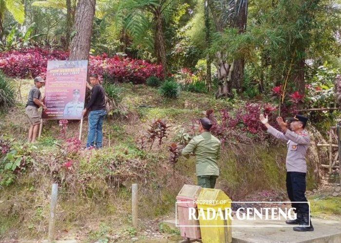 CEGAH KARHUTLA: Anggota Polsek Songgon memasang seruan di dekat kawasan wisata Rowo Bayu di Desa Bayu, Kecamatan Songgon, Selasa (3/10).