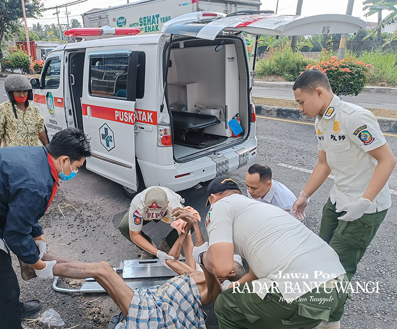TANPA IDENTITAS: Personel Satpol PP menggotong tubuh lansia yang ditemukan terkapar di tepi Jalan Gatot Subroto, Kelurahan Klatak, Kecamatan Kalipuro, Banyuwangi, Rabu (4/10).