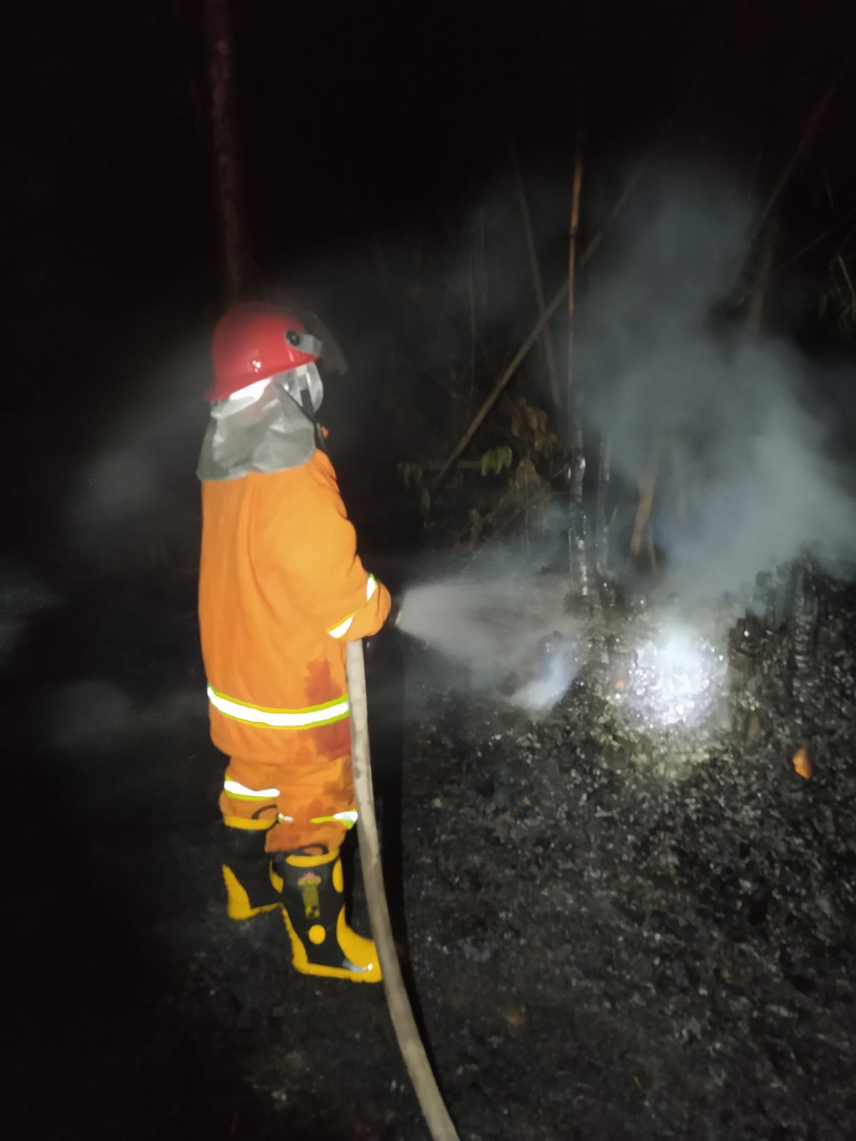 PENDINGINAN: Petugas Damkar Sektor Srono berusaha memadamkan api di lahan pekarangan yang terbakar di Dusun Kopen, Desa Kradenan, Kecamatan Purwoharjo pada Kamis (5/10) malam.