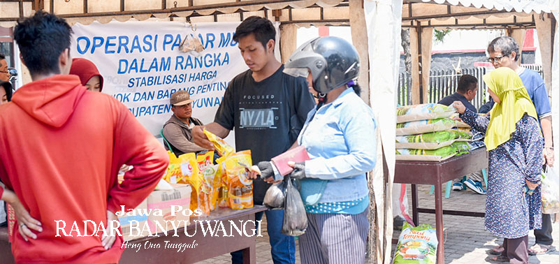 LEBIH TERJANGKAU: Sejumlah warga membeli bahan kebutuhan pokok di stan operasi pasar di kawasan Pasar Banyuwangi, Selasa (10/10).
