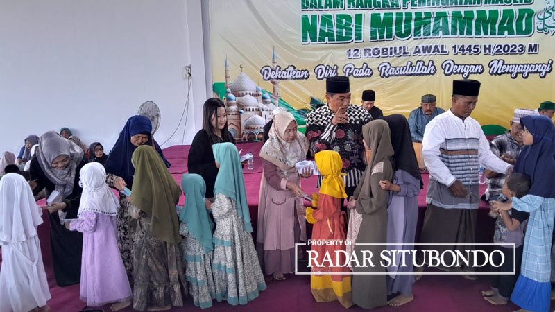Hj. Ardi Kusumawati Ahmad (kiri) istri pemilik CV Lintang Timur Jaya, H. Ahmad Mujiono, bersama keluarga besarnya membagikan rejeki kepada ratusan anak yatim di Desa Awar-Awar, Asembagus, Minggu (8/10